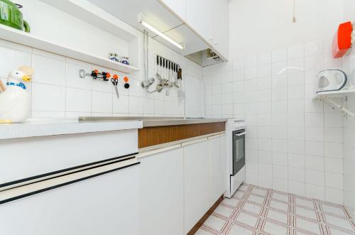 a kitchen with white tiled walls and counters at Apartment Neven in Trogir