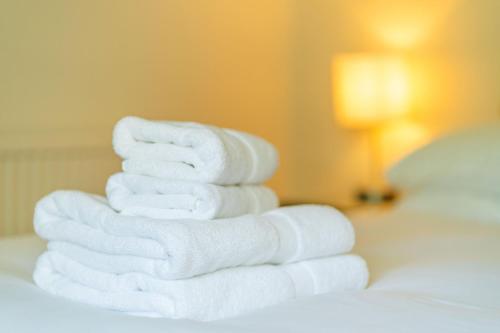 a stack of towels sitting on top of a bed at Kirkgate Cottage in Eassie and Nevay