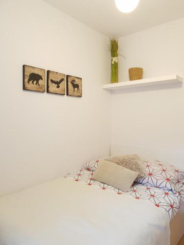 ザコパネにあるApartament Bolek i Apartament Lolekの白いベッドルーム(壁に3枚の写真が飾られたベッド付)