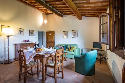 a dining room with a table and chairs and a couch at Villa S.Andrea in San Casciano in Val di Pesa