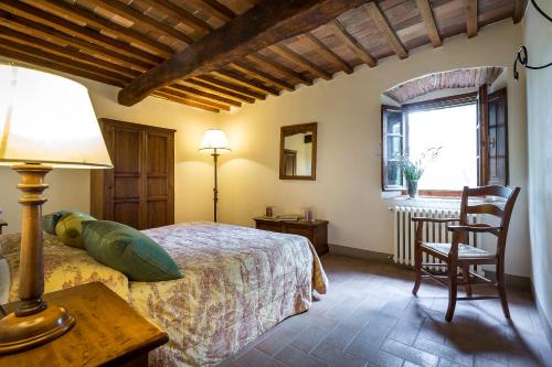 a bedroom with a bed and a table and a chair at Villa S.Andrea in San Casciano in Val di Pesa