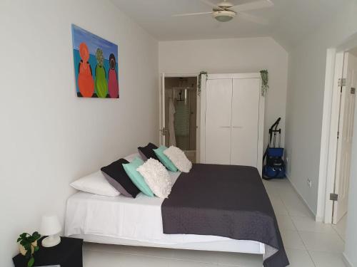 een slaapkamer met een groot bed met kussens erop bij A2 APARTMENT budget at JAN THIEL Curacao in Jan Thiel