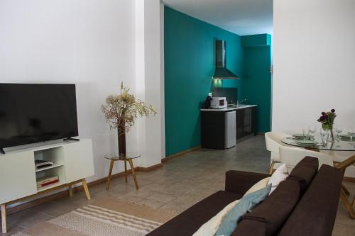 a living room with a couch and a tv at Bairro das Flores in Tomar