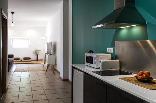 a kitchen with a counter top with a microwave at Bairro das Flores in Tomar