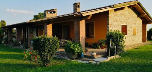 a small brick house with a dog in front of it at Bed & Breakfast Bellavista in Castiglione delle Stiviere