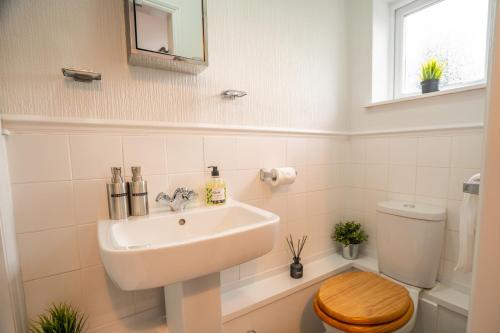 a bathroom with a sink and a toilet at Saltbox Stays- Large 3 bed house!! 3 bathrooms, garden, fast wifi, sleeps 6 in Swadlincote