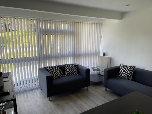 a living room with two couches and a large window at Chalet 208 In Glan Gwna Caernarfon in Caernarfon