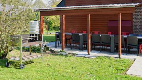 a patio with a table and chairs in the grass at Rêve d'Etretat in Bordeaux-Saint-Clair