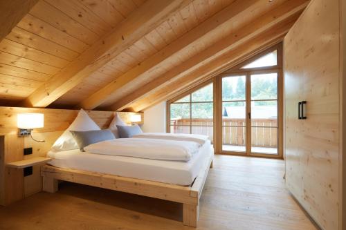 a bedroom with a bed in a wooden house at Zugspitzerei - Premium Chalet Ferienwohnungen in Grainau