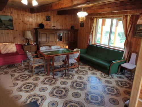 uma sala de estar com um sofá verde e uma mesa em Žalioji em Paduyelis