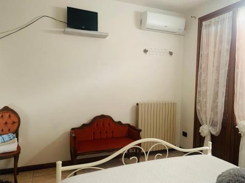 una camera da letto con un letto, una sedia e una finestra di Bed & Breakfast Bellavista a Castiglione delle Stiviere