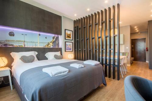 a bedroom with a large bed and a desk and acean at NEW! Apartamento Galé (wifi, estacionamento, elevador) 418 in Porto