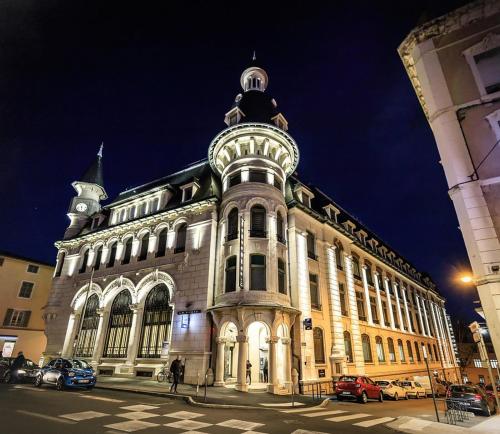 a large building with a tower on top of it at Appartement La Roseraie PARKING PRIVE in Mâcon