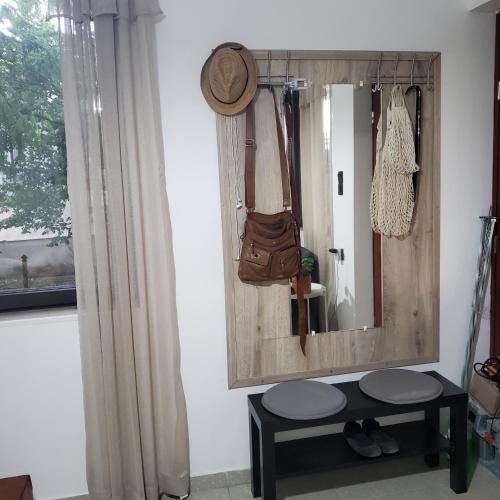 a mirror on a wall with a bench and a hat at Duna House Duna Ház in Tass