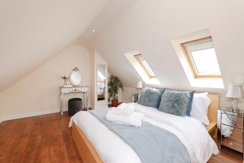a bedroom with a large white bed with blue pillows at ALTIDO Greenknowes Estate - Retreat With Garden, Parking and Hot Tub in Kelty