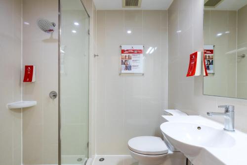 uma casa de banho com um chuveiro, um WC e um lavatório. em Red Planet Bangkok Asoke - SHA Extra Plus em Bangkok