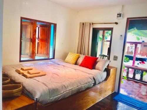 a bedroom with a large bed with a large window at Free Concept Beach Resort in Srithanu