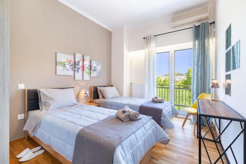 a bedroom with two beds and a balcony at Katsanis luxury apt., stunning view of acropolis in Athens