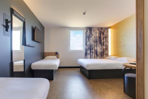 Ένα ή περισσότερα κρεβάτια σε δωμάτιο στο B&B HOTEL Reims Croix Blandin