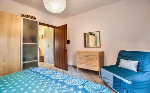 a bedroom with a blue bed and a chair at Porto Alabe Sardegna.... a due passi dal mare in Tresnuraghes
