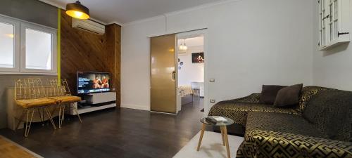 a living room with a couch and a tv at Oro Apartments Tirana in Tirana