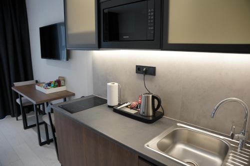 a kitchen counter with a sink and a microwave at BUKA Apart-Hotel & SPA in Bukovel