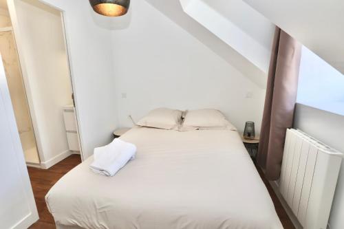 a bedroom with a white bed in a attic at Napoléon Gare 8 T2 Dernier Etage ByLocly in Pontivy