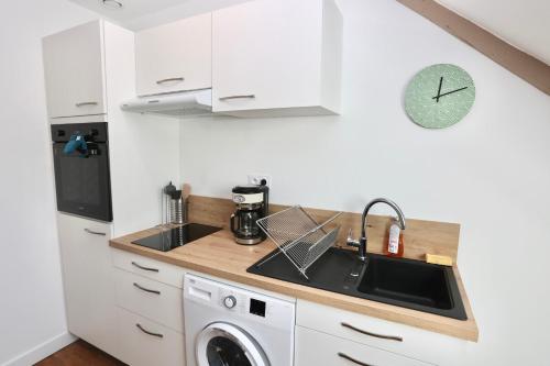 a kitchen with a sink and a washing machine at Napoléon Gare 8 T2 Dernier Etage ByLocly in Pontivy