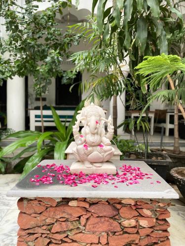 a statue sitting on top of a pile of flowers at Inn Seventh Heaven in Pushkar