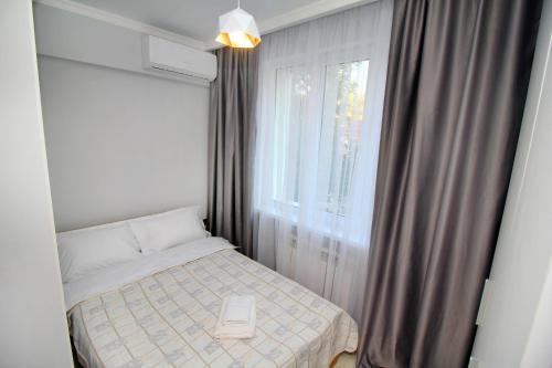 a small bedroom with a bed and a window at Cozy studio in the best area! 3 in Almaty