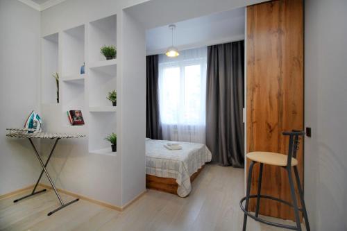 Habitación pequeña con cama y ventana en New and cozy studio in the best area!, en Almaty