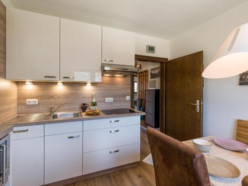 una cucina con mobili bianchi e un tavolo da pranzo di Zahmer Kaiser a Oberaudorf