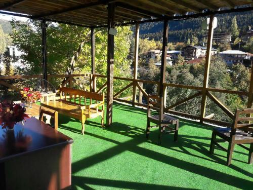 a screened in porch with chairs and a table and a view at Guest House Mari30 in Mestia