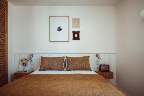 a bedroom with a bed and two pictures on the wall at Hôtel Monsieur Aristide in Paris