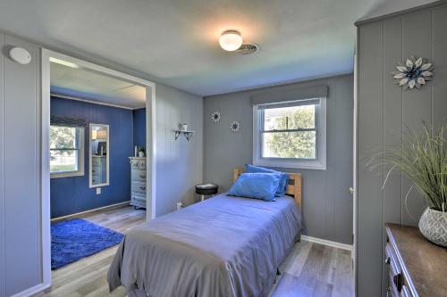 1 dormitorio con cama con sábanas azules y ventana en Quiet New York Retreat Less Than 7 Miles to Skiing! en Homer