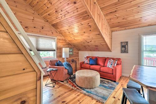 a living room with a red couch and a table at Mountain View Escape - 1 Mile to White River! in Mountain View