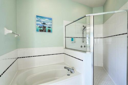 a white bathroom with a sink and a shower at Merritt Island Home with Grill and Saltwater Pool in Merritt Island