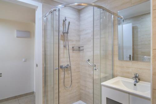 a shower with a glass door next to a sink at Marina view sunny apartment in Fuengirola