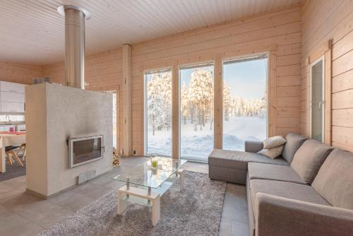 sala de estar con sofá y chimenea en Rokovan Helmi - Natural peace in Ruka-Kuusamo, en Ruka