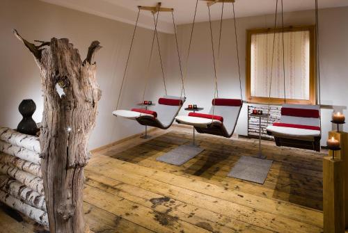 a room with a group of chairs and a tree stump at Berghotel Rehlegg in Ramsau