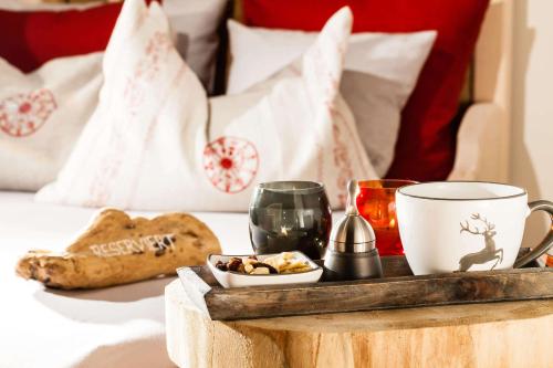 a tray with cookies and coffee on a bed at Berghotel Rehlegg in Ramsau