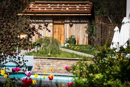 a garden with a wooden building and a swimming pool at Berghotel Rehlegg in Ramsau