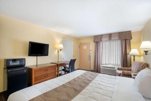 a hotel room with a bed and a flat screen tv at Quality Inn White Springs Suwanee in Live Oak