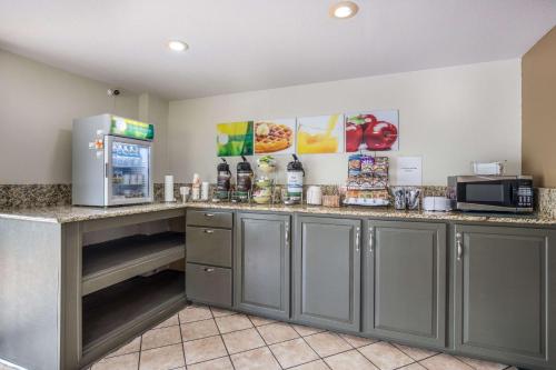 a kitchen with a counter with a microwave and a refrigerator at Quality Inn White Springs Suwanee in Live Oak