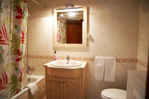 een badkamer met een wastafel, een toilet en een spiegel bij Pôr-do-Sol Alvor in Alvor
