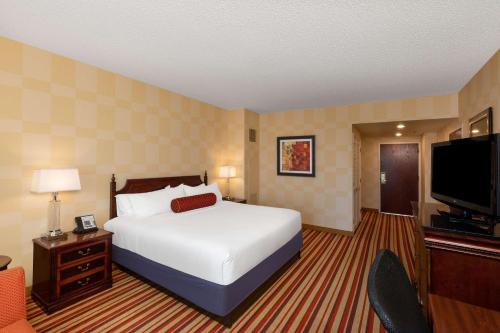 a hotel room with a bed and a flat screen tv at Wyndham Grand Oklahoma City Downtown in Oklahoma City