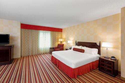 a hotel room with a large bed and a television at Wyndham Grand Oklahoma City Downtown in Oklahoma City
