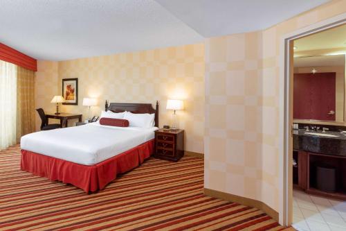 a hotel room with a bed and a bathroom at Wyndham Grand Oklahoma City Downtown in Oklahoma City