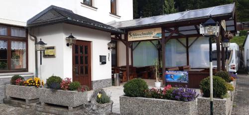 a building with flowers in pots in front of it at Frühstückspension "Schlösselmühle" in Jöhstadt