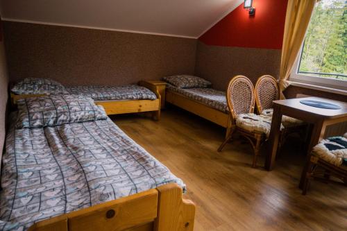 a room with two beds and a table and chairs at Apartament Dana in Szczyrk
